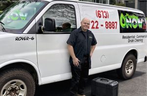 Friendly Ottawa Plumber standing in front of service van at residential home